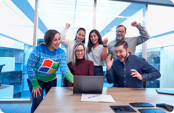 Team celebrating in front of a laptop