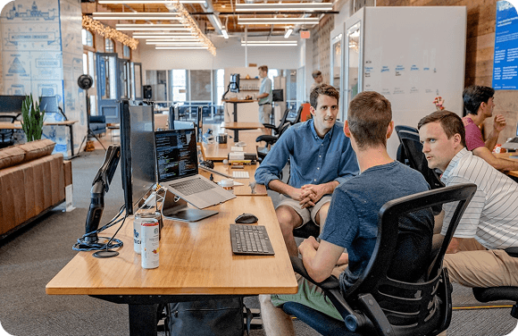 Developer team collaborating around a laptop